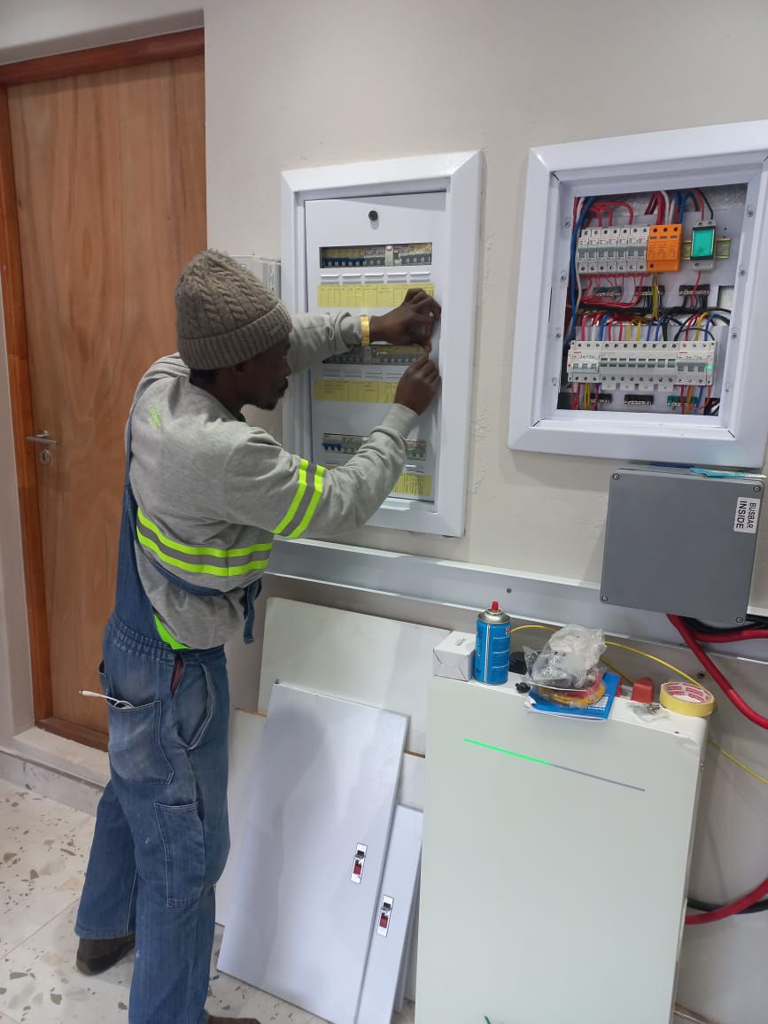 Electrician working on commercial distribution boards with surge protection